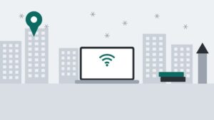 雪の結晶が舞う街並みと時計台風の建物、ノートPC、積んだ本、地図のピンを描いたイラスト